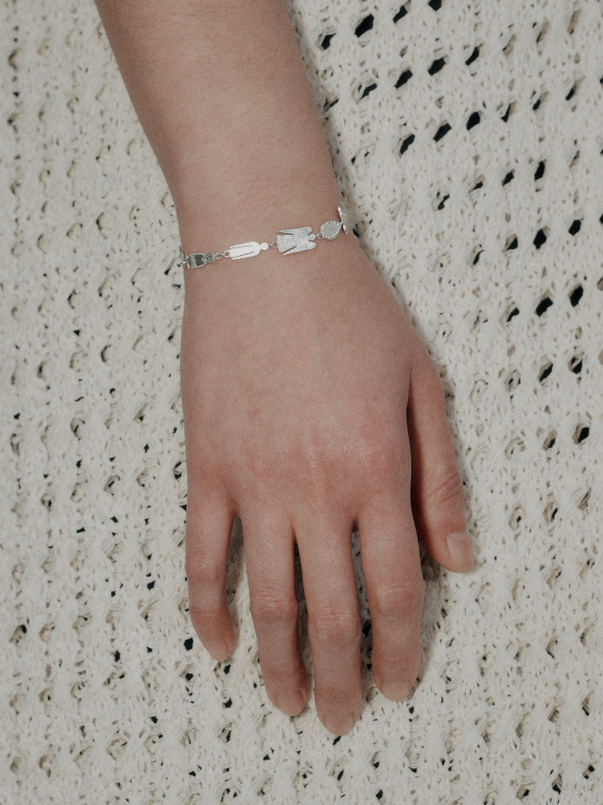 Silver ball charm bracelet with small links worn on wrist