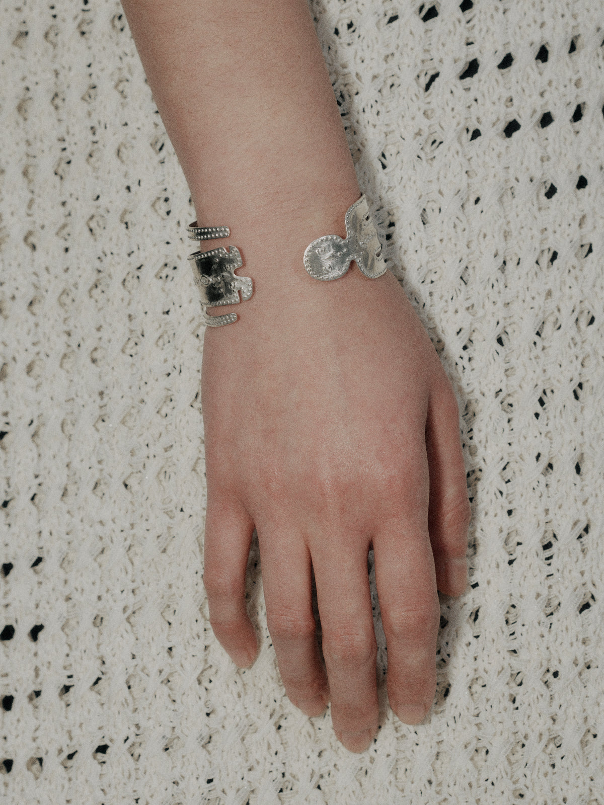 Silver yoga man bangle with stacked charm details on wrist