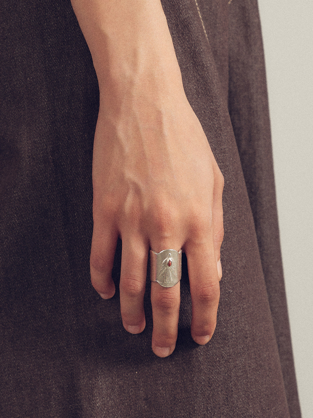 Silver bird-man engraved ring on hand