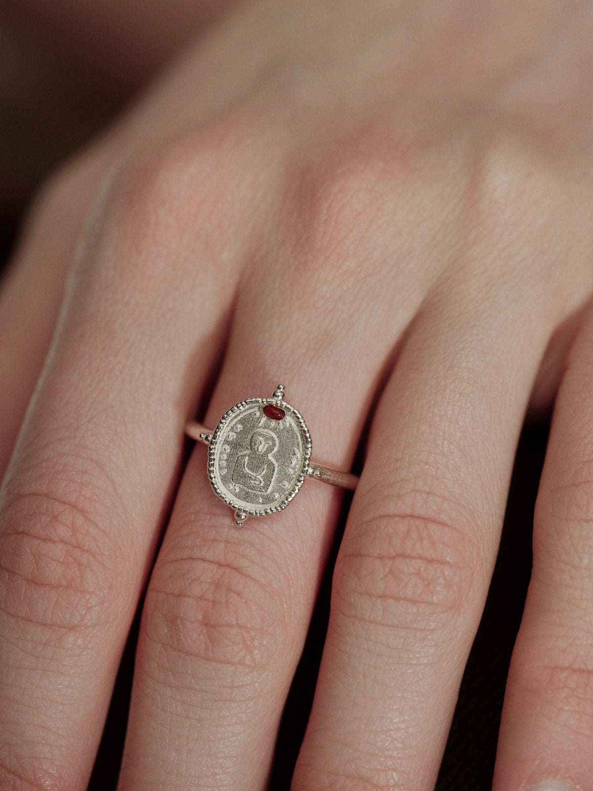 Silver oval coin ring with engraved figure and red onyx center