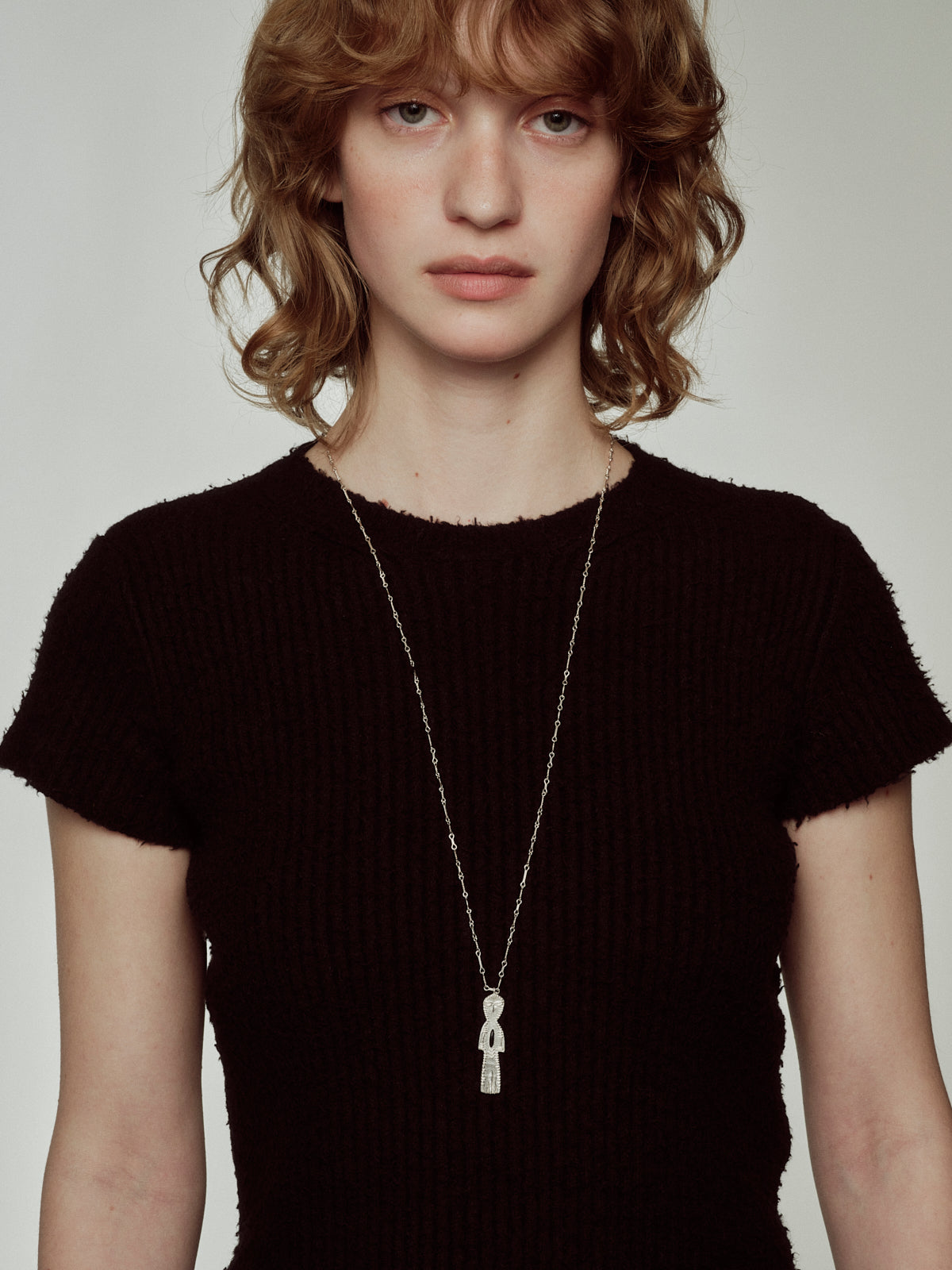Long silver chain necklace with small rectangular charm pendant