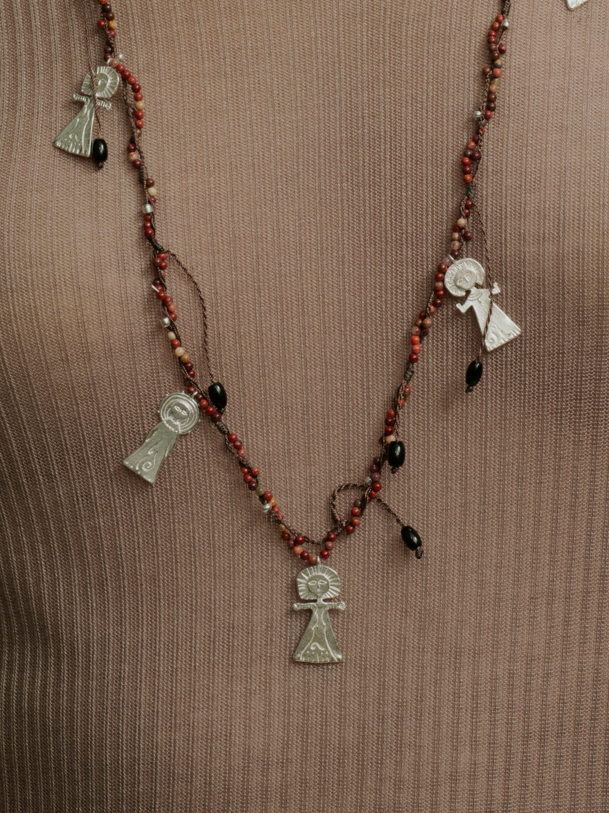 Long beaded necklace with red-black beads and silver charm pendants