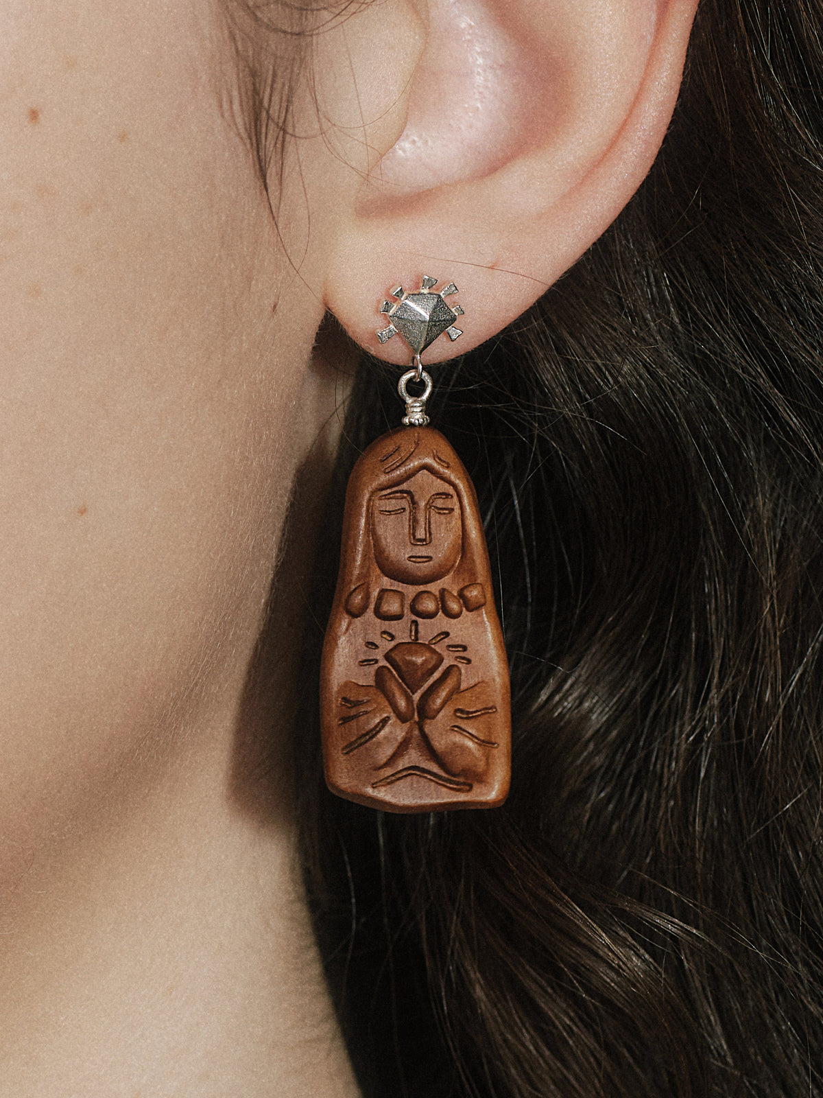 Bronze-toned dangling earrings with sculpted face and hand charm