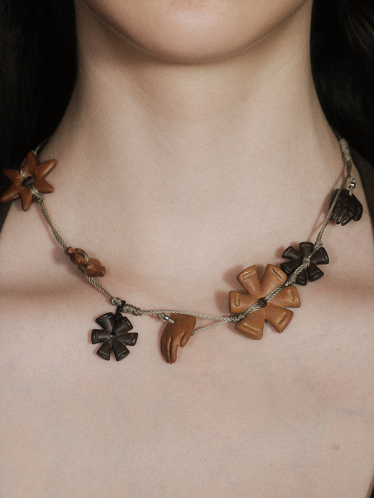 Charm necklace with black flower and star, brown hand and heart pendants